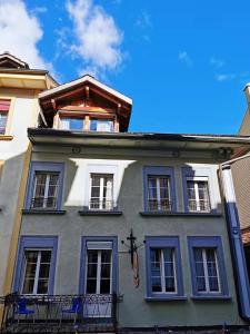 ein blau-weißes Gebäude mit Fenstern und einem Balkon in der Unterkunft Interlaken apartment 27 in Interlaken