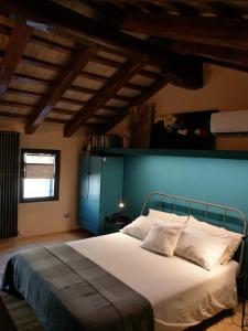 sypialnia z dużym łóżkiem z niebieską ścianą w obiekcie Relais San Rocco w mieście Mira