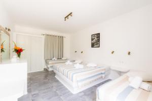 three beds in a room with white walls at Paradise Beach Resort in Paradise Beach