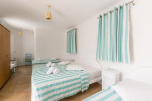 a bedroom with two beds with teddy bears on the bed at Paradise Beach Resort in Paradise Beach