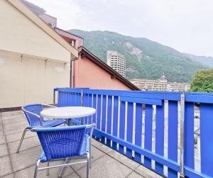 einen Tisch und Stühle auf einem Balkon mit einem blauen Zaun in der Unterkunft Interlaken apartment 27 in Interlaken