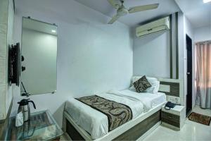 una piccola camera con letto e specchio di Hotel City View a Navi Mumbai