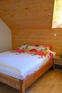 ein Schlafzimmer mit einem Bett in einer Holzhütte in der Unterkunft Ranč Stojnšek in Rogaška Slatina