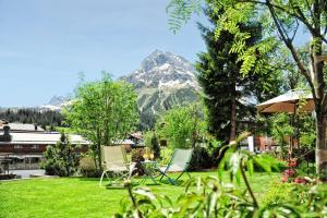 dos sillas en un patio con una montaña en el fondo en Haldenhof, en Lech am Arlberg