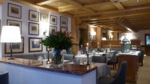 una sala da pranzo con tavoli, sedie e lampada di Haldenhof a Lech am Arlberg