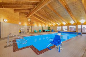 una gran piscina cubierta con sillas azules en un edificio en AmericInn by Wyndham Havre, en Havre