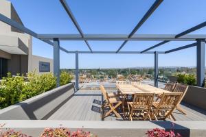 a deck with wooden tables and chairs on a building at MAE Singular Hotel in Cordoba