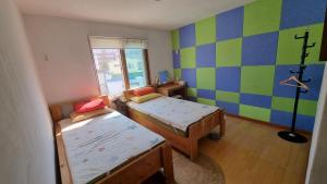 a small room with two beds and a window at Tongyeong One Guesthouse in Tongyeong