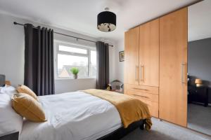 1 dormitorio con 1 cama, vestidor y ventana en The Albert Road Flat, en Worcester