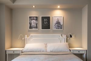 布宜諾斯艾利斯的住宿－Up América Plaza，卧室配有一张墙上三幅照片的床