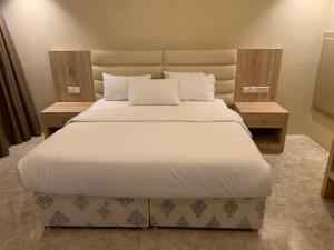 a hotel room with a white bed and white comforter at Almakan Hotel 113 in Riyadh