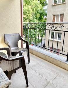 a chair on a balcony with a view of a building at Cozy Studio next to State Opera with Work Space in Stara Zagora