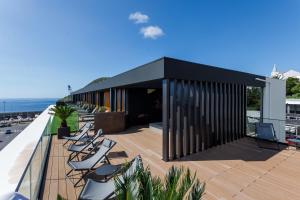 a balcony with lounge chairs on a roof at The Shipyard - Angra in Angra do Heroísmo