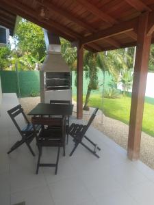 a grill on a patio with two chairs and a table at Casa paraíso estaleirinho Balneário Camboriú in Balneário Camboriú