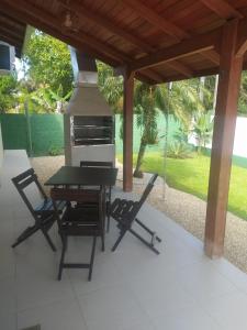 una parrilla en un patio con 2 sillas y una mesa en Casa paraíso estaleirinho Balneário Camboriú, en Balneário Camboriú