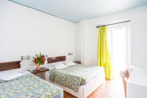 a bedroom with two beds and a window at Paradise Beach Resort in Paradise Beach