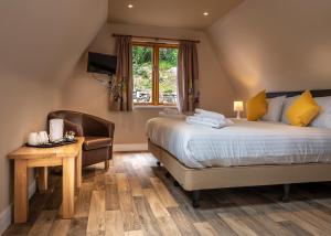 a bedroom with a bed and a desk and a chair at The Poltimore Inn in North Molton
