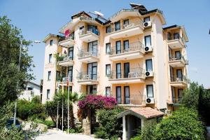 ein hohes Gebäude mit Blumen davor in der Unterkunft Begonville Apart Hotel in Side