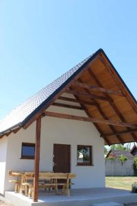 a building with a picnic table and a roof at Domek letniskowy 6-osobowy całoroczny nad jeziorem Wilczyńskim in Świętne