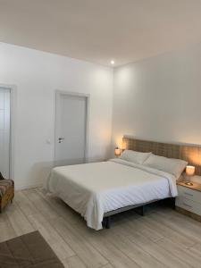 biała sypialnia z dużym łóżkiem i 2 lampami w obiekcie MÁLAGA VELARDE cENTER w Maladze