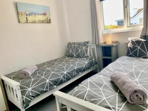 a small bedroom with two beds and a chair at Bungalow33 Benllech in Benllech