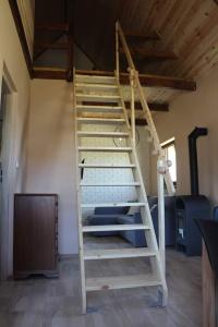 a wooden ladder in a room with a ceiling at Domek letniskowy 6-osobowy całoroczny nad jeziorem Wilczyńskim in Świętne