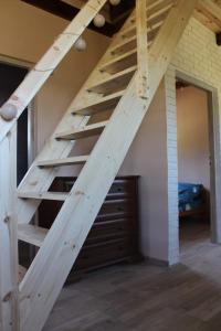 a wooden staircase in a room with a bedroom at Domek letniskowy 6-osobowy całoroczny nad jeziorem Wilczyńskim in Świętne