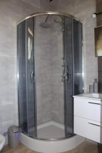 a shower with a glass door in a bathroom at Domek letniskowy 6-osobowy całoroczny nad jeziorem Wilczyńskim in Świętne