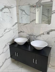 a bathroom with two sinks on top of a black cabinet at Luxusvilla Neubau 2 in Oberasbach