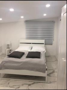 um quarto branco com uma cama grande e almofadas pretas em Luxusvilla Neubau 1 em Oberasbach