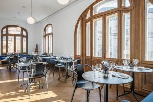 a restaurant with tables and chairs and windows at Casa Popeea Boutique Hotel in Brăila