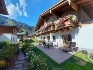a house with a patio with a table and benches at Hochalmbahnen Chalets Rauris 1-06WE4, Maislaufeldweg 1g OG in Rauris