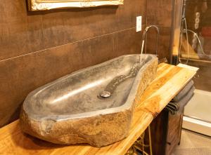 uma banheira de pedra sentada num balcão de madeira na casa de banho em Lausitzer Seenland em Hoyerswerda