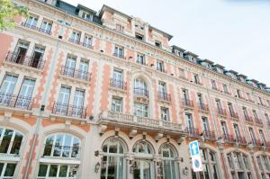 a large building with balconies on the side of it at Grand Hôtel Du Tonneau D'Or in Belfort