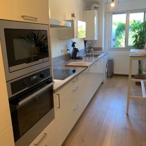 a kitchen with white cabinets and a sink at Appartement Le 17 in Narbonne
