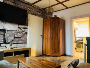 a living room with a table and a tv on a wall at Lausitzer Seenland in Hoyerswerda