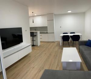 sala de estar con sofá, TV y mesa en Central Аpartment Foca - with garage en Foča