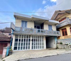 a house with a balcony on top of it at Homestay Srikandi Syariah Dieng RedPartner in Diyeng