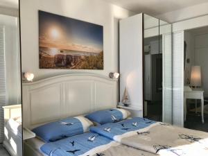 ein Schlafzimmer mit einem Bett mit blauen Kissen darauf in der Unterkunft Panoramablick Ostseefjord Schlei in Schleswig