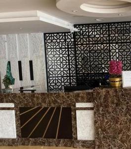 a living room with a white wall and a black and white checkered at Almakan Hotel 113 in Riyadh