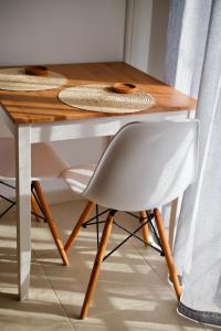 een houten tafel met een witte stoel naast een bureau bij Aristotle's Studio in Kalamata
