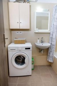 een witte wasmachine in een badkamer met een wastafel bij Aristotle's Studio in Kalamata