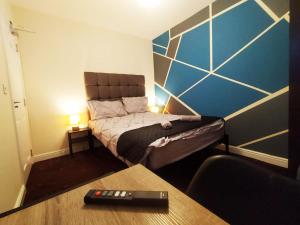 a small bedroom with a bed in a room with a table at Bankwell Guest House in Manchester