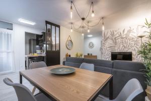 a dining room with a table and a couch at La feuillette - vieille ville - parking gratuit in Annecy