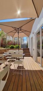 patio ze stołem, krzesłami i parasolem w obiekcie Casa BARR w mieście Trafaria