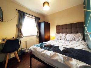 1 dormitorio con cama, escritorio y ventana en Bankwell Guest House en Mánchester