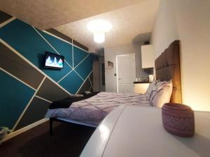 a bedroom with a bed and a tv on the wall at Bankwell Guest House in Manchester