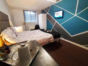 a bedroom with a bed and a table with dishes on it at Bankwell Guest House in Manchester
