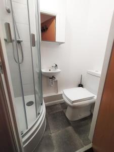 a bathroom with a shower and a toilet and a sink at Bankwell Guest House in Manchester
