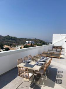 une table à manger et des chaises sur le toit dans l'établissement Luxury Penthouse Gerardo - The View Fuengirola, à Fuengirola